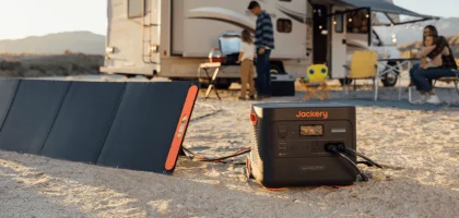 Jackery solar generator 1000 pro and solarsaga 200w solar panels out in the middle of a field with a campervan.