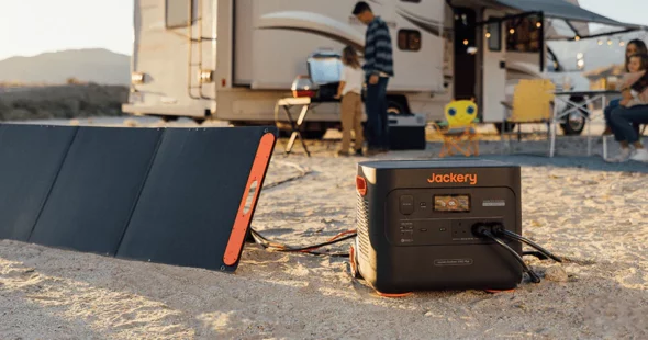 Jackery solar generator 1000 pro and solarsaga 200w solar panels out in the middle of a field with a campervan.